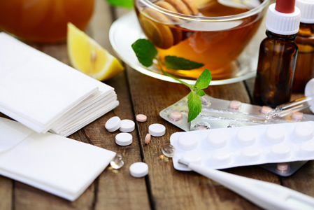 Tabletten und Erkältungstee auf einem Tisch